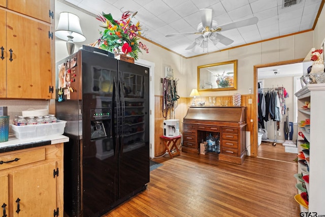 kitchen featuring black fridge, light hardwood / wood-style flooring, ceiling fan, and ornamental molding