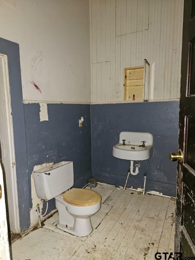 823 W Louisiana St, Palestine, TX 75801 - half bathroom with hardwood / wood-style floors and wooden walls