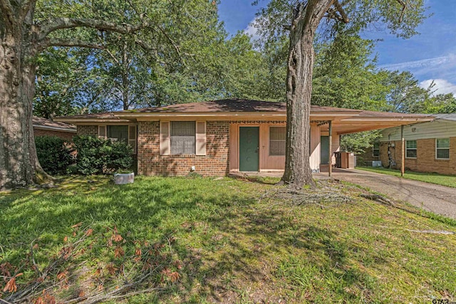 3131 Greg Ln, Tyler, TX 75701 - single story home with a front yard, a carport, brick siding, and driveway