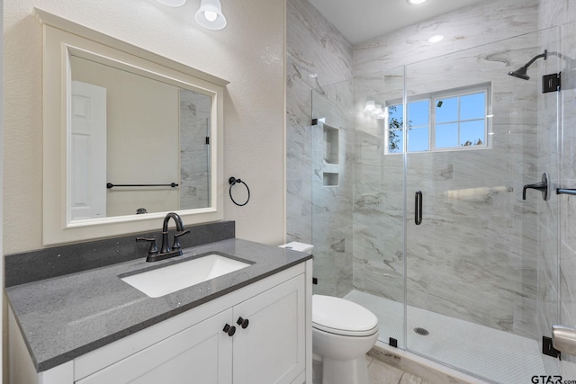 bathroom with vanity, a shower with shower door, and toilet