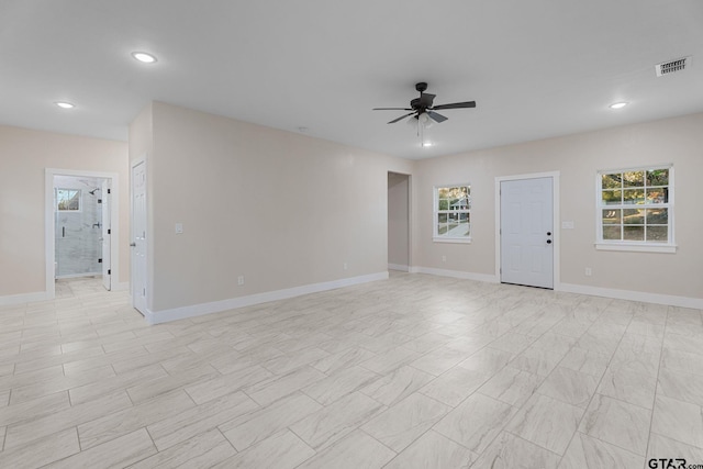 unfurnished room with ceiling fan and a healthy amount of sunlight