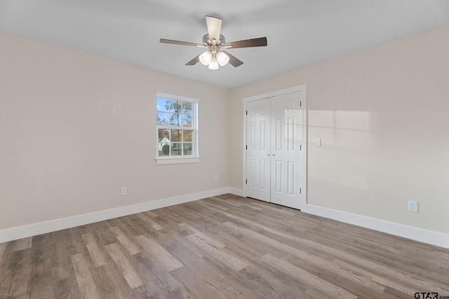 unfurnished bedroom with ceiling fan, light hardwood / wood-style floors, and a closet