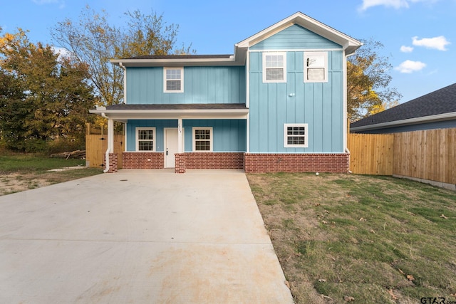 view of front of house featuring covered porch and a front lawn