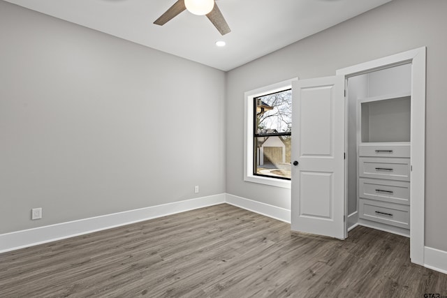 unfurnished bedroom with ceiling fan and dark hardwood / wood-style flooring