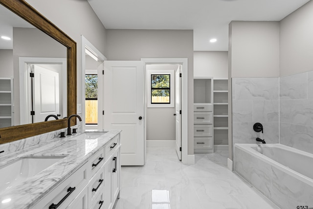 bathroom featuring vanity and a relaxing tiled tub