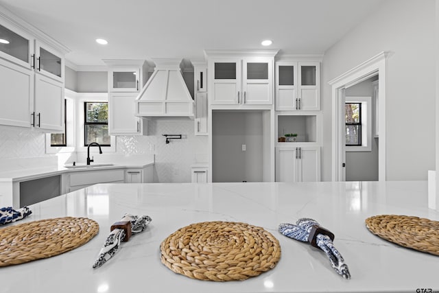 21019 C R 116, Tyler, TX 75703 - kitchen with a sink, premium range hood, white cabinets, light stone counters, and backsplash