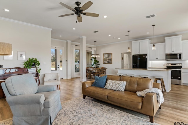 living room with light hardwood / wood-style flooring, ceiling fan, and crown molding