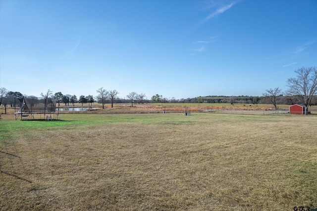 view of yard with a rural view and a trampoline