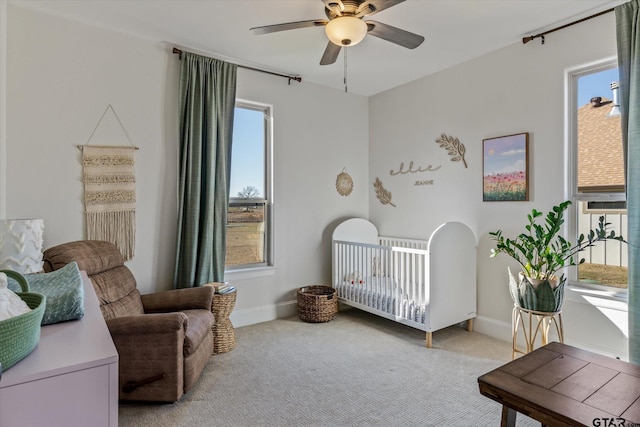 bedroom featuring a crib, multiple windows, and ceiling fan