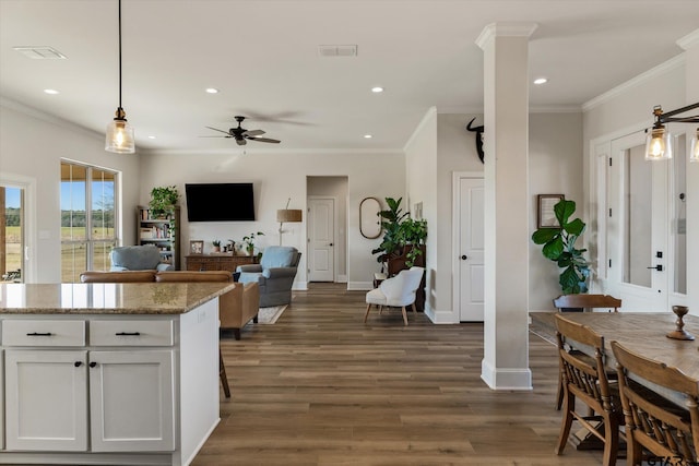 kitchen with ceiling fan, light stone countertops, ornate columns, decorative light fixtures, and white cabinetry