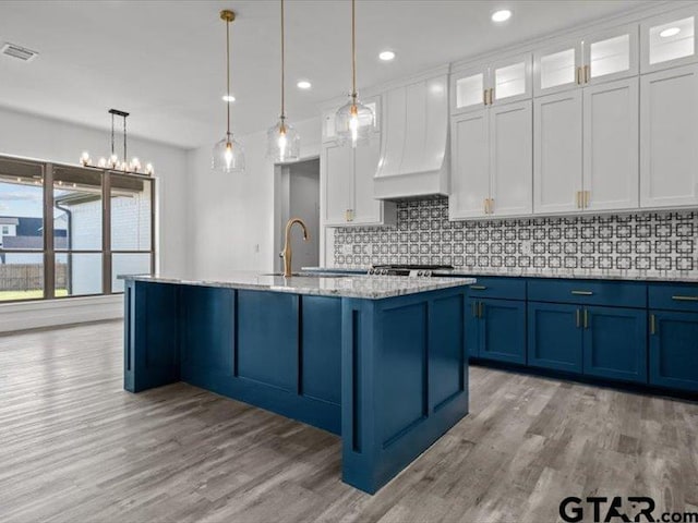 12237 Harlon St, Flint, TX 75762 - kitchen with backsplash, light wood finished floors, white cabinetry, and blue cabinetry