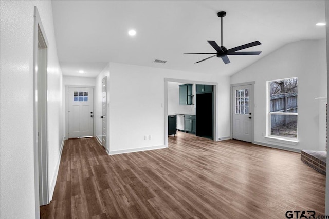 unfurnished living room featuring ceiling fan, dark hardwood / wood-style flooring, and vaulted ceiling