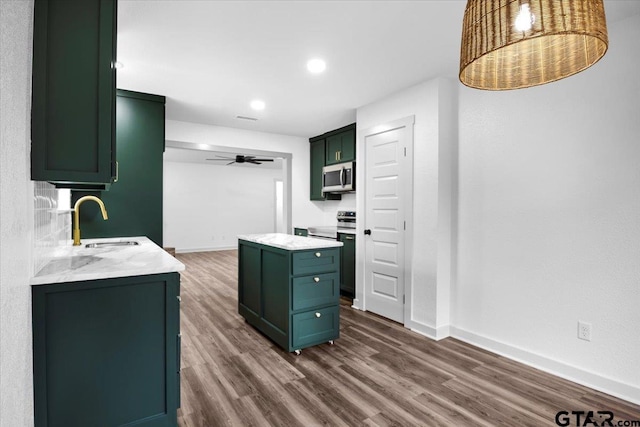 kitchen featuring sink, green cabinetry, dark hardwood / wood-style floors, a kitchen island, and ceiling fan