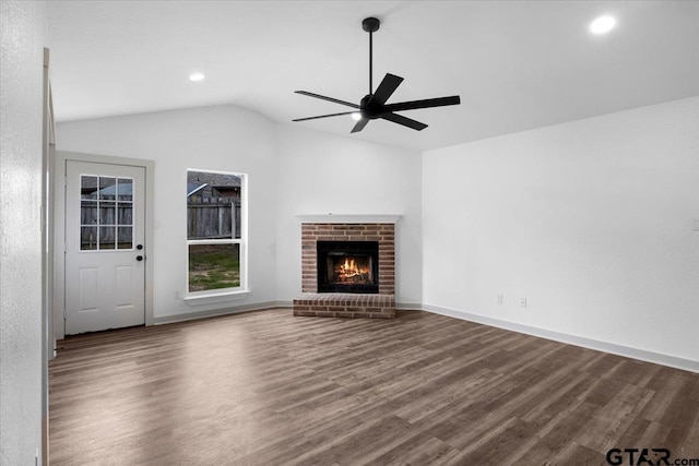 unfurnished living room with hardwood / wood-style flooring, ceiling fan, a fireplace, and vaulted ceiling