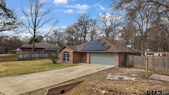 view of front of home featuring a garage, a front lawn, and solar panels