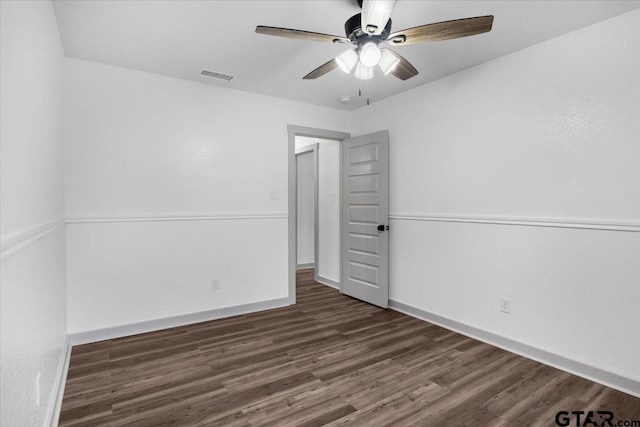 empty room featuring dark wood-type flooring and ceiling fan