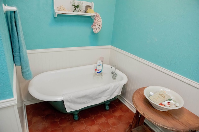 bathroom with a washtub and tile patterned flooring