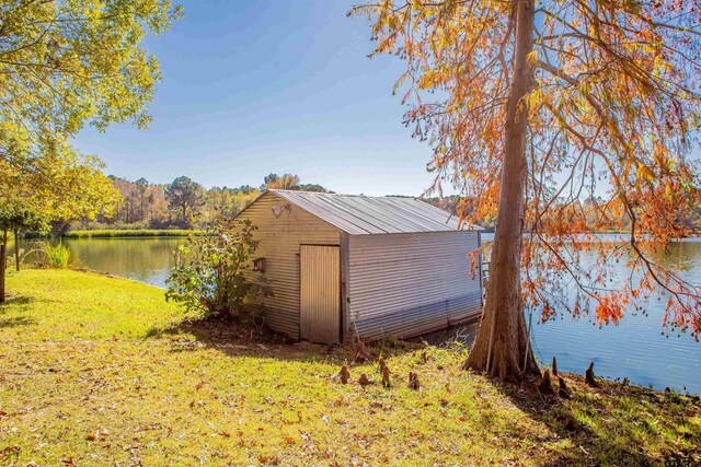 view of outbuilding featuring a water view and a yard