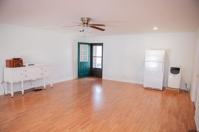 empty room with ceiling fan and light hardwood / wood-style flooring