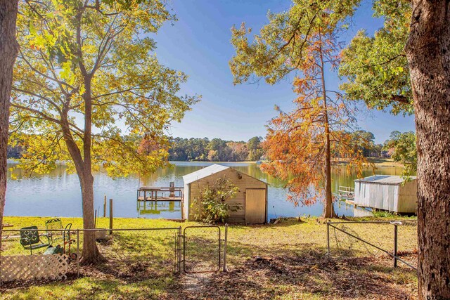 view of yard featuring a water view and a boat dock