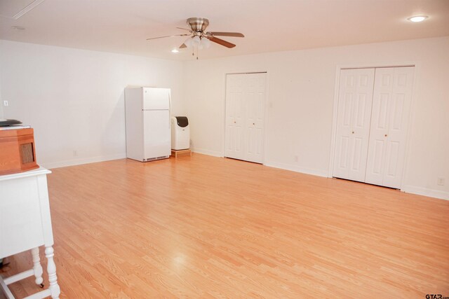 unfurnished living room with ceiling fan and light hardwood / wood-style floors