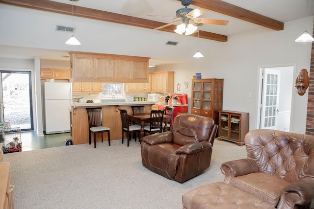 carpeted living room with a high ceiling, beamed ceiling, and ceiling fan