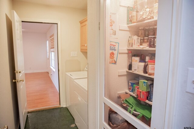 washroom with cabinets, hardwood / wood-style flooring, and separate washer and dryer