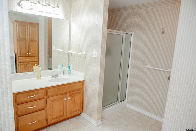 bathroom featuring a shower with shower door and vanity