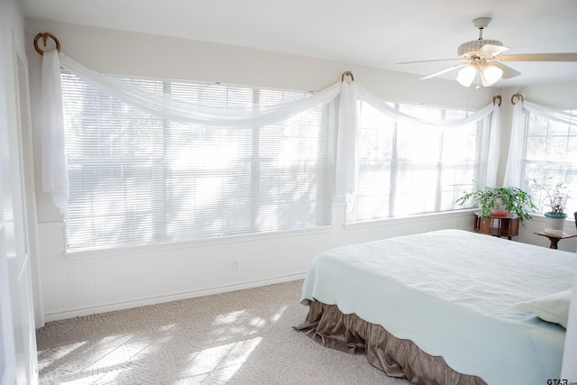 carpeted bedroom with multiple windows and ceiling fan