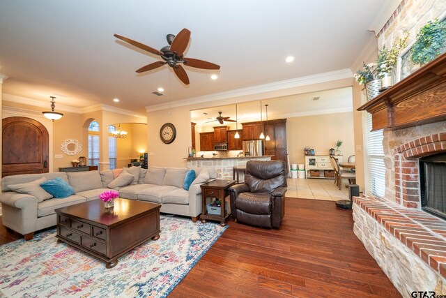 living room with a fireplace, a wealth of natural light, hardwood / wood-style flooring, and crown molding