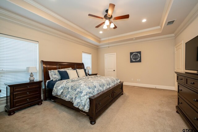 carpeted bedroom featuring a tray ceiling, ceiling fan, and crown molding