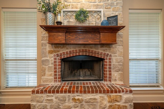 room details featuring hardwood / wood-style floors and a stone fireplace