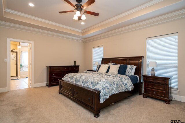 bedroom featuring ensuite bathroom, ceiling fan, multiple windows, and light carpet