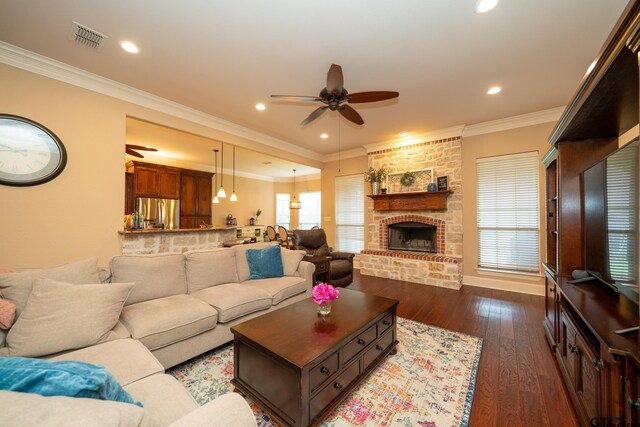 living room featuring ornamental molding, a fireplace, dark wood-type flooring, and ceiling fan