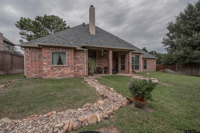 rear view of house with a yard