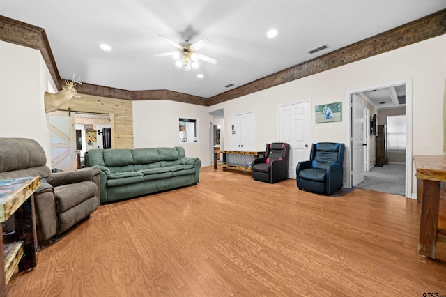 living room featuring light hardwood / wood-style floors, a barn door, and ceiling fan