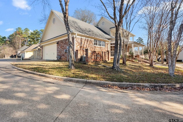 view of front of property with central air condition unit and a front yard