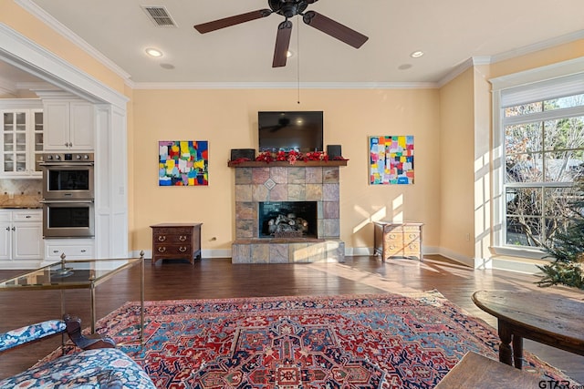 living room with a fireplace, wood-type flooring, ceiling fan, and ornamental molding