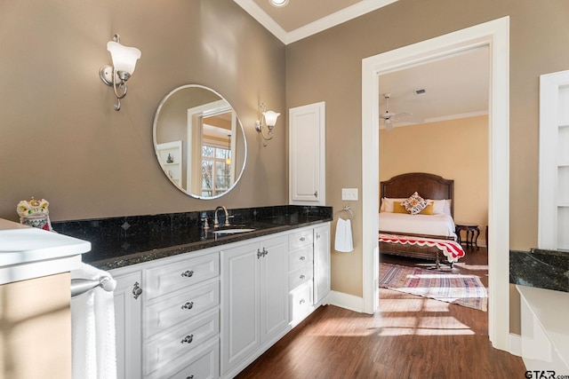 bathroom with vanity, hardwood / wood-style flooring, ceiling fan, and ornamental molding