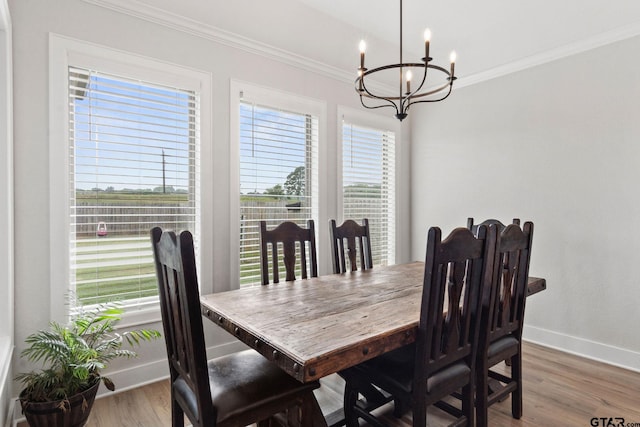 dining room with wood-type flooring, crown molding, and an inviting chandelier