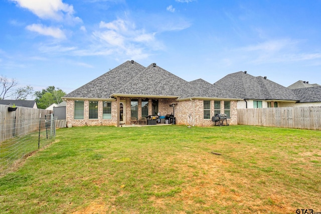 rear view of property featuring a lawn and a patio area