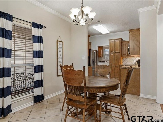 dining area featuring ornamental molding, light tile patterned floors, a notable chandelier, and a textured ceiling