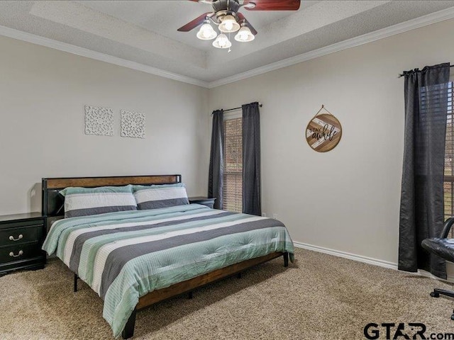 carpeted bedroom featuring a raised ceiling, ornamental molding, and ceiling fan