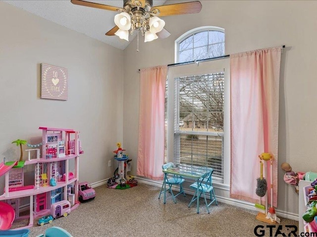 recreation room with vaulted ceiling, ceiling fan, and carpet floors