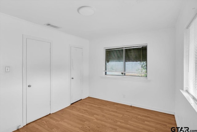 unfurnished bedroom with baseboards, visible vents, and light wood-style flooring