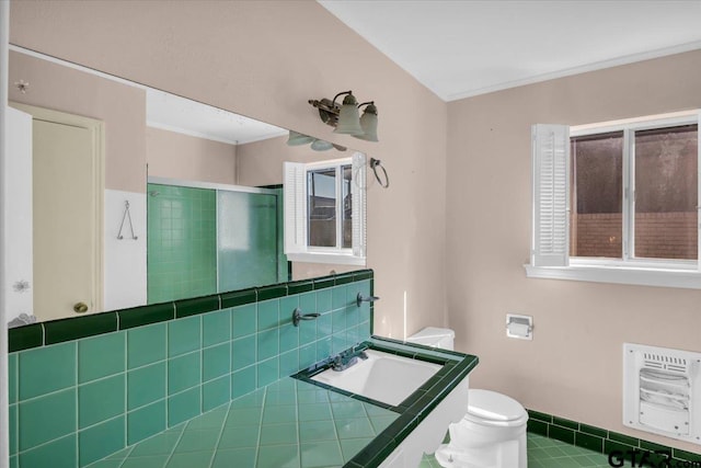 full bath featuring a shower stall, tile patterned floors, heating unit, toilet, and a sink