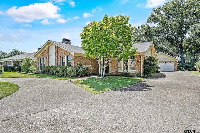 view of front of house featuring a front yard, a chimney, and brick siding