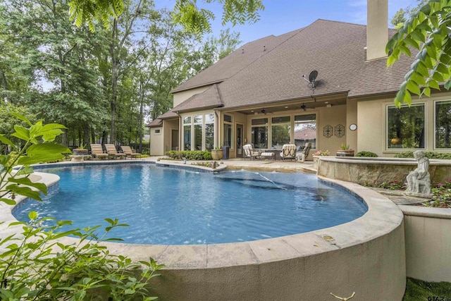 pool with a patio, a ceiling fan, and an outdoor living space