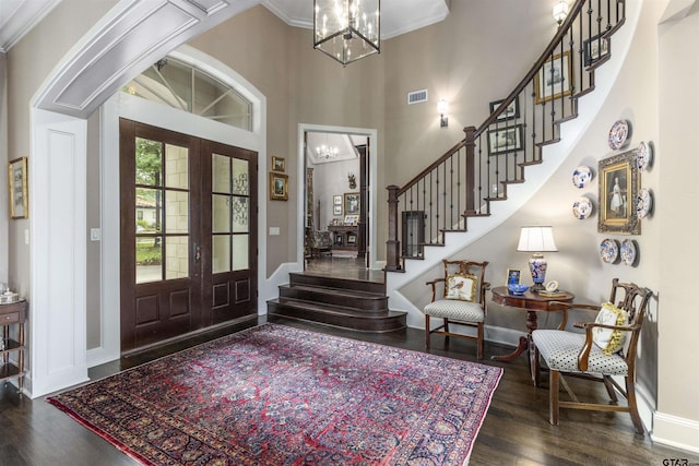 foyer with visible vents, wood finished floors, a notable chandelier, and french doors