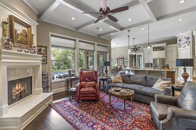 living area featuring dark wood finished floors, a ceiling fan, recessed lighting, a high end fireplace, and coffered ceiling